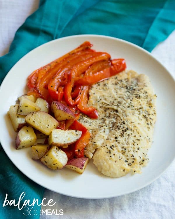 One Pan Meals: Basil Parmesan Tilapia with Roasted Red Peppers and Potatoes. One-sheet pan tilapia filet dinner for the whole family! Roasted veggies are quick to prep and easy to bake. Even a little sweet from the roasted red peppers! Tilapia is affordable but dresses up nice to give you the protein you crave, along with basil and parmesan flavors. #balance365meals #onepanmeals