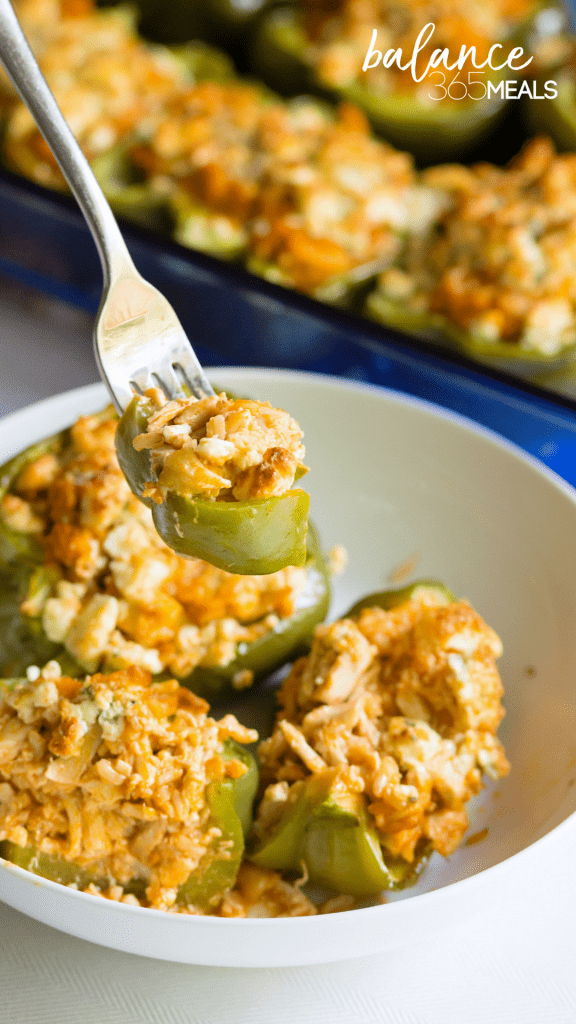 Buffalo Chicken Stuffed Peppers - Green bell peppers roasted and stuffed with brown rice and chicken smothered in yummy buffalo hot sauce. Creamy blue cheese crumbles are melted over the top and the peppers cut through like butter. Everyone gets their own stuffed pepper for supper and leftovers can easily be reheated in the oven. Trade out the green peppers for red bell peppers for added sweetness!